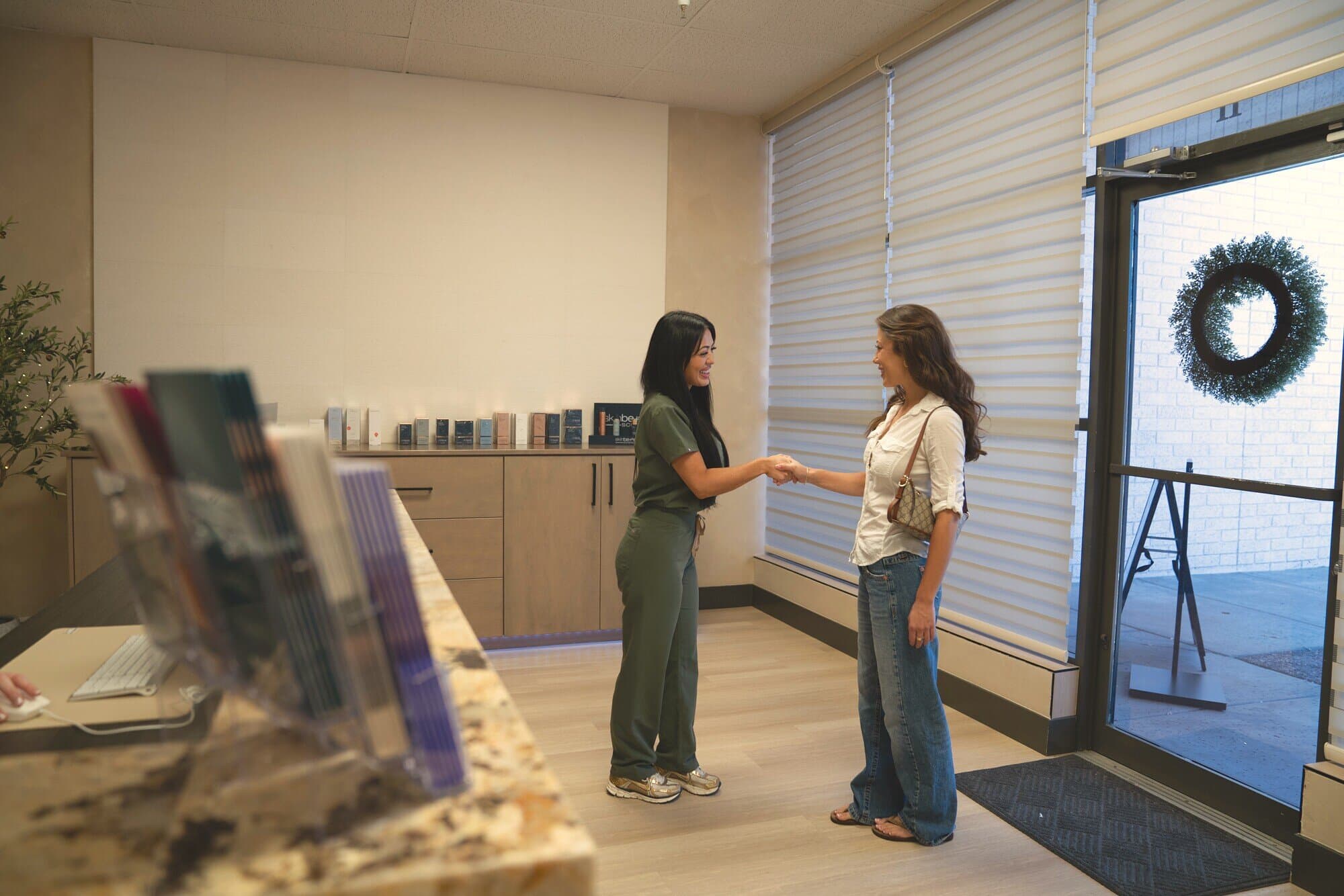 A team member welcomes a guest in the reception at éclat Spa & Wellness in North Phoenix